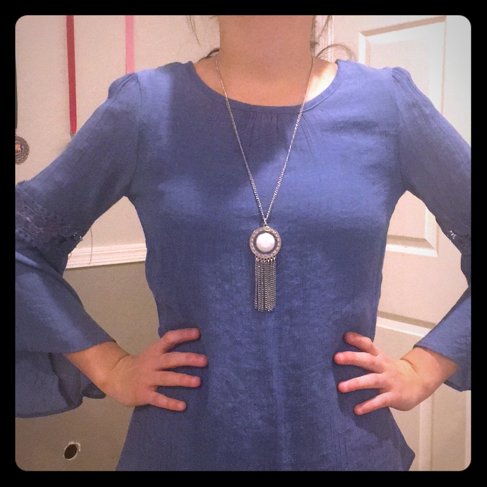 A blue long sleeved shirt with patterns